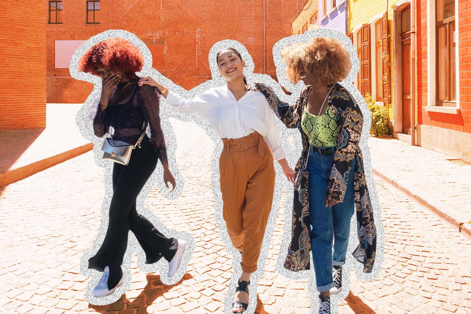 Three young women walk down a street