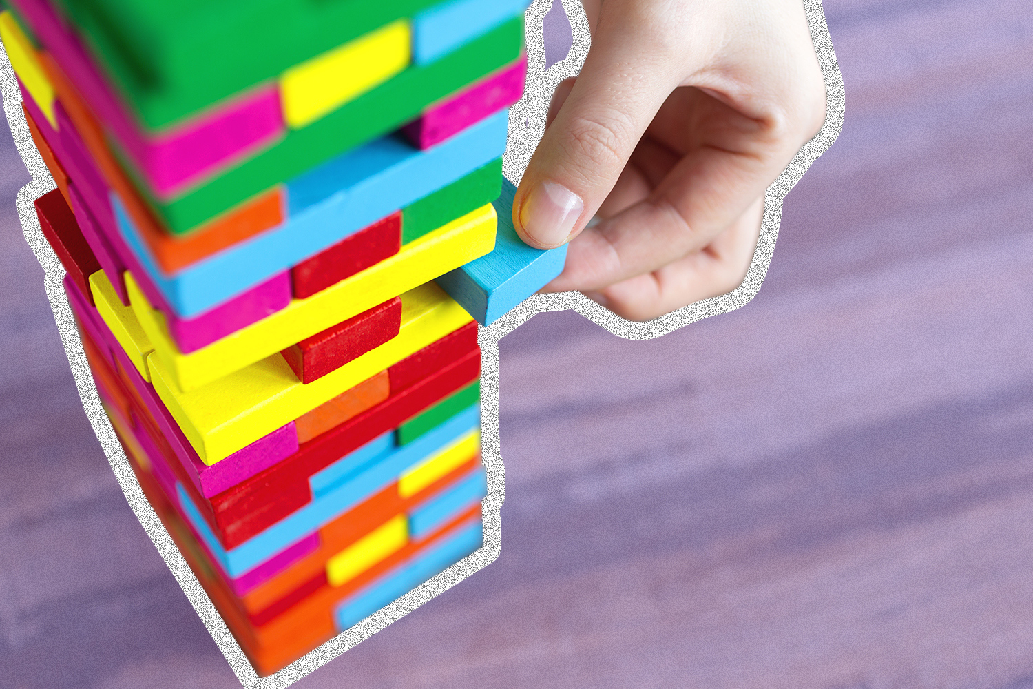 Image of person adding a block to a tower of blocks