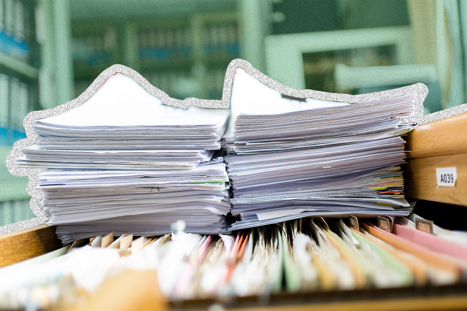 papers stacked on an open filing cabinet drawer