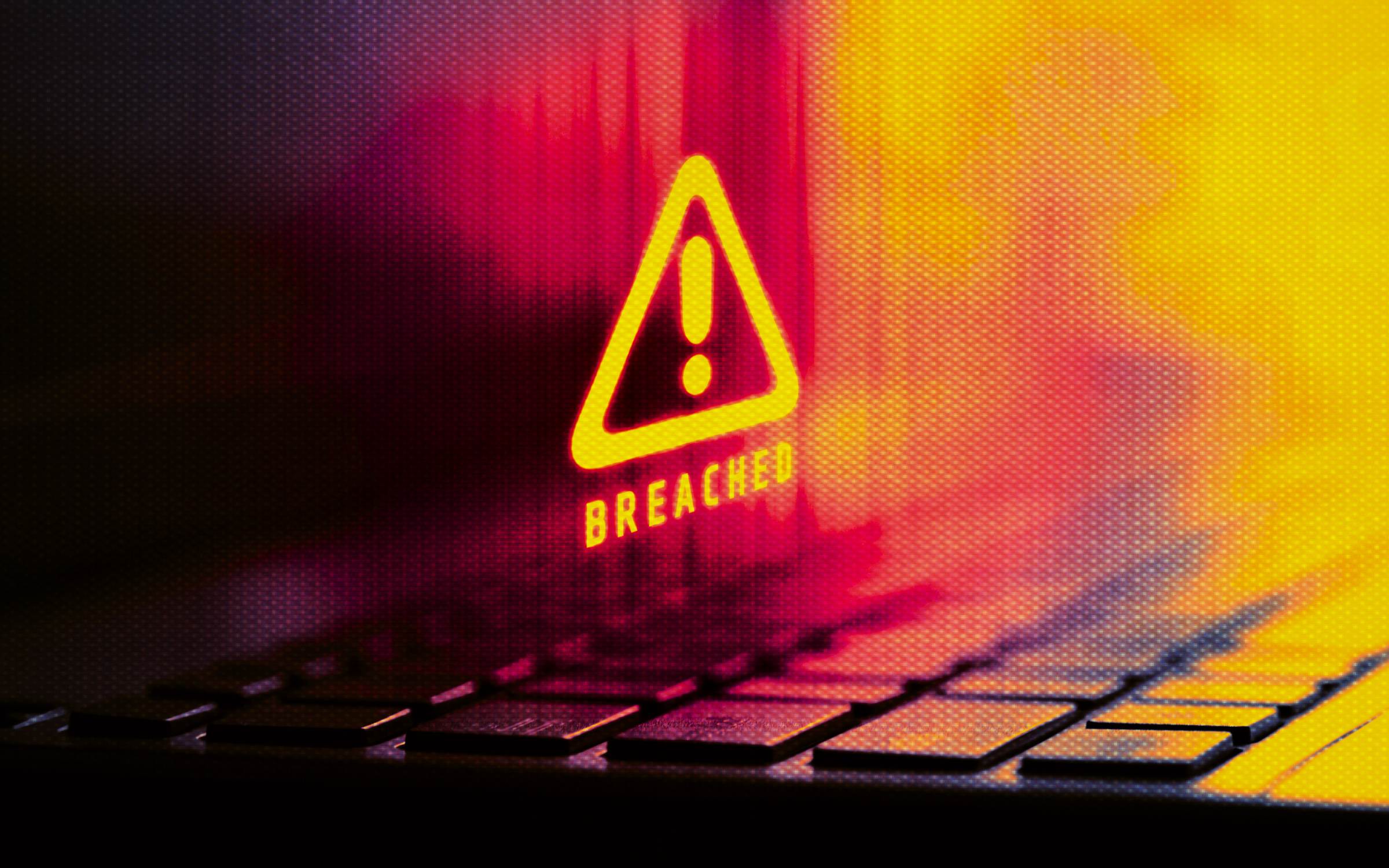 A digital warning symbol with the word “BREACHED” hovers above a keyboard, illuminated in red and yellow tones. The image reflects cybersecurity themes of system vulnerability, unauthorized access, threat detection, and digital exposure. It represents a moment of alert within networked environments—where breaches trigger protocol shifts, data integrity is reassessed, and the interface between user and infrastructure becomes a focal point of scrutiny.